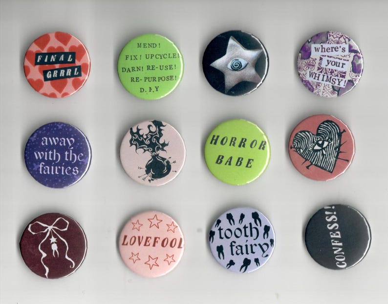 Pu&ograve; includere: Una collezione di dodici bottoni rotondi con vari disegni e testi. I bottoni presentano frasi come "FINAL GRRRL", "HORROR BABE" e "CONFESS!!". Altri bottoni hanno illustrazioni di una stella, un cuore con un occhio e una fatina dei denti.