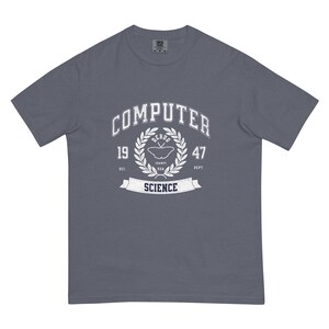 Op de afbeelding: Een leisteenblauw t-shirt met een wit grafisch ontwerp. Het ontwerp toont het woord "COMPUTER" boven een laurierkrans. Binnen de krans bevinden zich een vlinder en de woorden "DEBUG" en "SCIENCE". Het shirt is van het merk Comfort Colors.