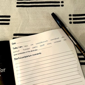 Black and white square page-a-day postpartum journal for new moms.