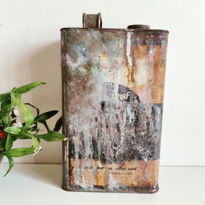 May include: A vintage metal container with a faded, multi-coloured design. The container is rusty brown with white and blue paint accents. The container has a deer silhouette and the text "reef" printed on the front.