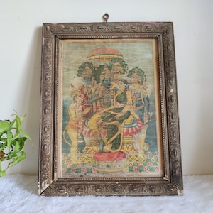 May include: An antique framed print depicting a religious scene with multiple figures. The print features vibrant colours, including greens, yellows, and blues, within a detailed, ornate wooden frame. The frame has a distressed, aged appearance.