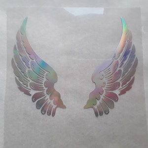 Op de afbeelding: Een paar iriserende engelenvleugels, met een gedetailleerd ontwerp, worden getoond op een witte achtergrond.