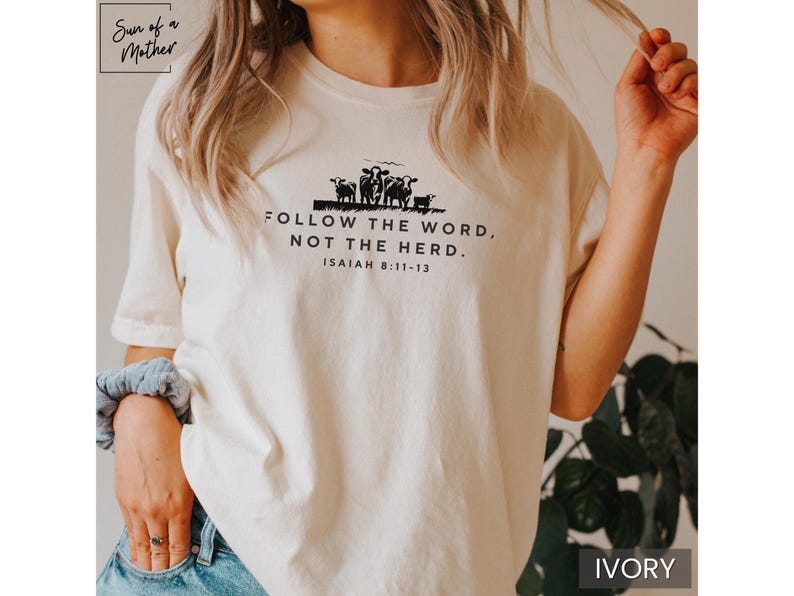 Peut inclure: Un t-shirt blanc avec un graphique noir d'un groupe de moutons et le texte "FOLLOW THE WORD, NOT THE HERD. ISAIAH 8:11-13".