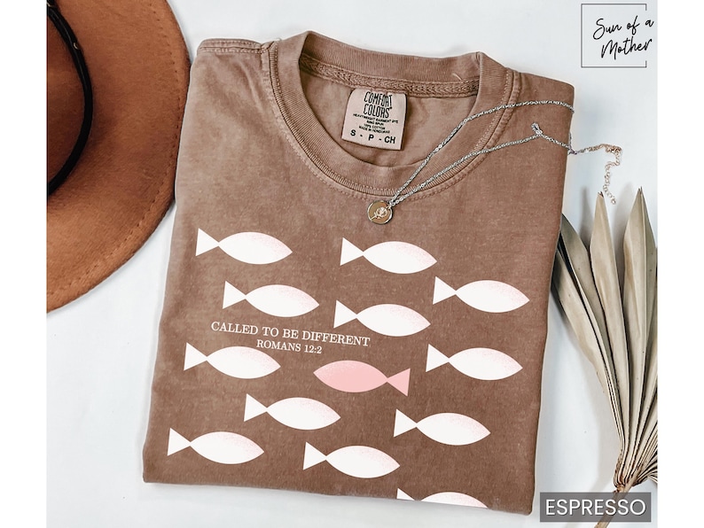 May include: A brown t-shirt with a white graphic of fish and the text "CALLED TO BE DIFFERENT ROMANS 12:2".