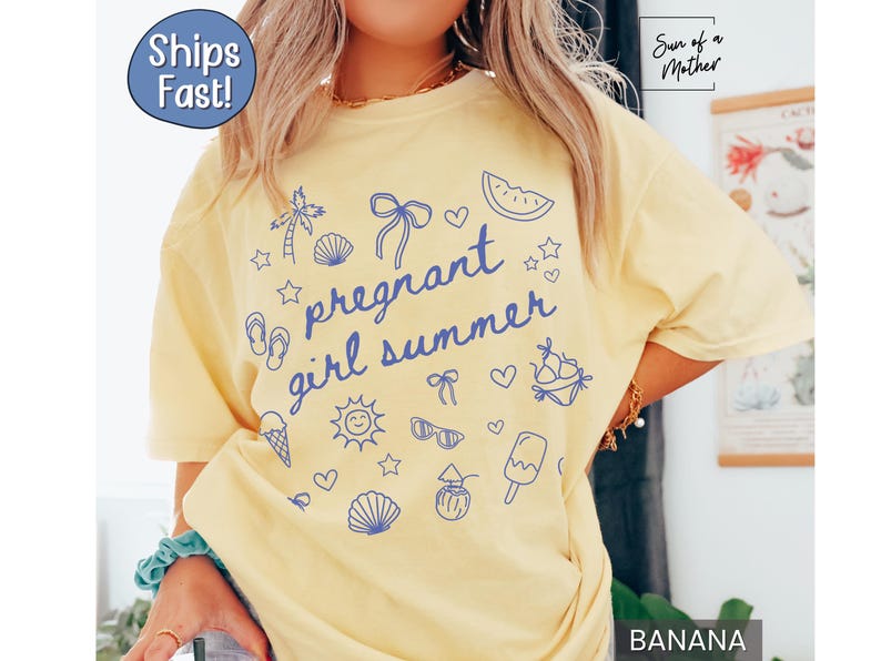May include: A light yellow t-shirt with the phrase "pregnant girl summer" in blue script, surrounded by summer-themed illustrations. The shirt has a relaxed fit and is made of soft material.