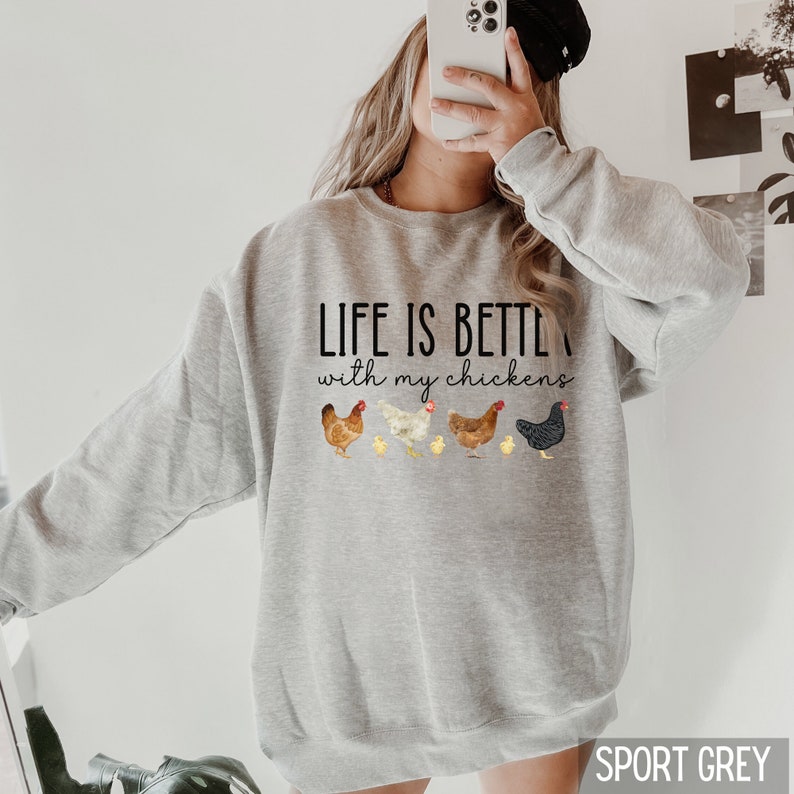May include: A gray sweatshirt with the text "Life is better with my chickens" and a graphic of five chickens and chicks. The sweatshirt is available in the color Sport Grey.