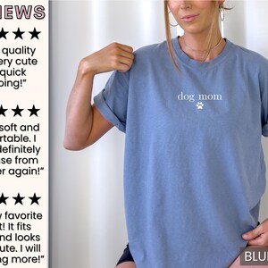 May include: A blue jean t-shirt with the text "dog mom" and a paw print in white.