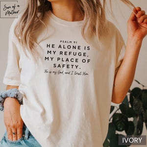 May include: A white t-shirt with the text "PSALM 91 HE ALONE IS MY REFUGE, MY PLACE OF SAFETY. He is my God, and I trust Him." printed in black.