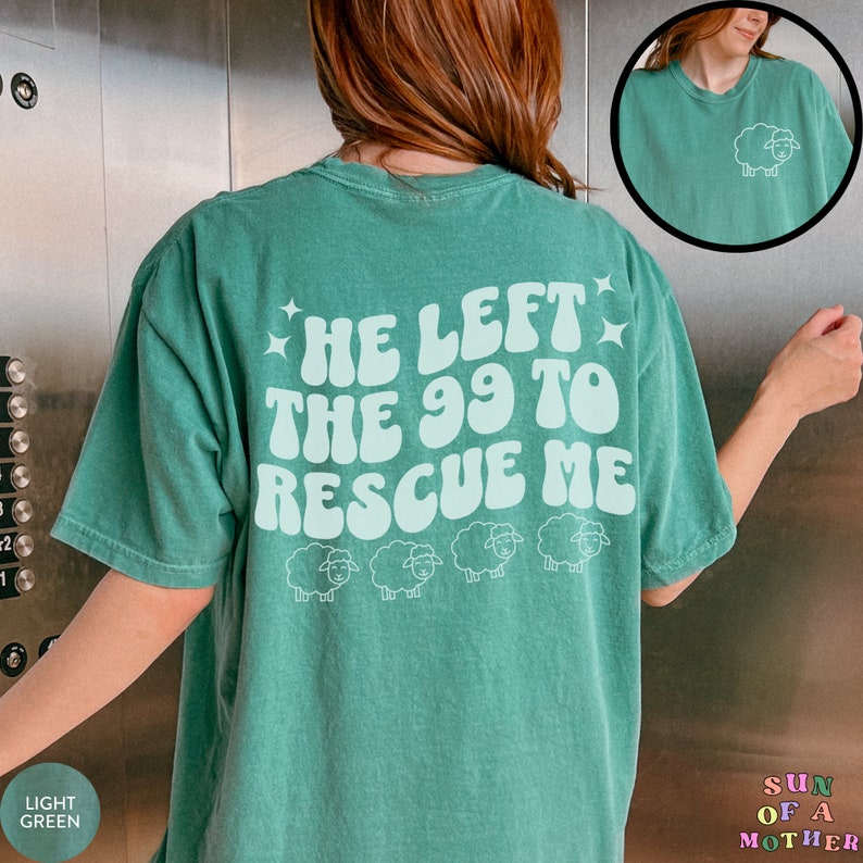 May include: A light green t-shirt with the text "He left the 99 to rescue me" in a retro font. There are four white sheep silhouettes below the text.