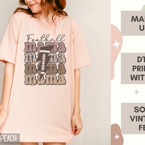 Puede incluir: Una camiseta rosa con el texto "Football mama" en una fuente retro con un gr&aacute;fico de f&uacute;tbol y un rayo. La camiseta est&aacute; hecha en los EE. UU. e impresa con tinta. Tiene una sensaci&oacute;n suave y vintage.