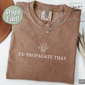 May include: A brown t-shirt with a white graphic of a potted plant and the text "I'd Propagate That".