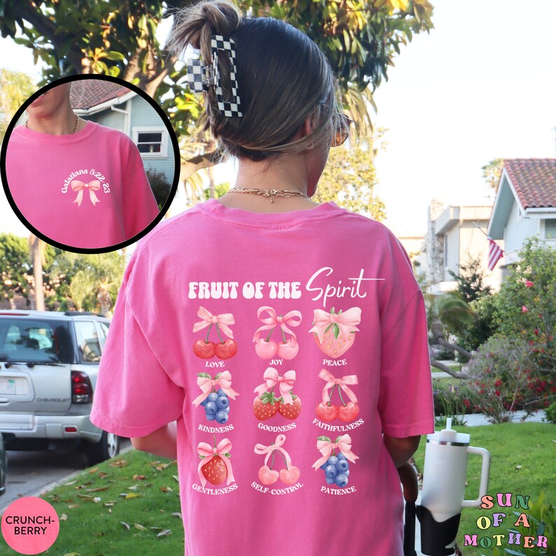 May include: Pink t-shirt with the text "Fruit of the Spirit" and a graphic of cherries, strawberries, and blueberries with bows. The text below each fruit includes the words: Love, Joy, Peace, Kindness, Goodness, Faithfulness, Gentleness, Self-Control, and Patience.