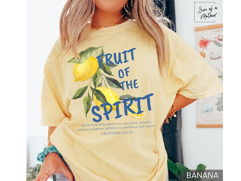 Op de afbeelding: Een geel T-shirt met een blauwe afbeelding waarop "Fruit of the Spirit" staat met citroenen en bladeren. De tekst onder de afbeelding luidt "But the fruit of the spirit is love, joy, peace, patience, kindness, goodness, faithfulness, gentleness, self control. Galatians 5:22-23".