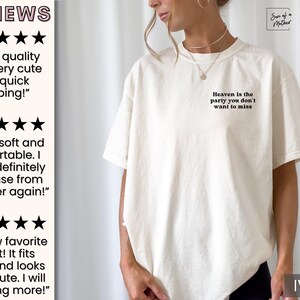 May include: A white t-shirt with the text "Heaven is the party you don't want to miss" printed on the front. The shirt is shown on a model and the color is ivory.