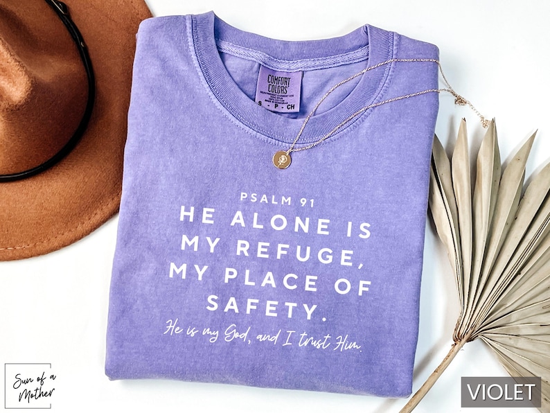May include: A purple t-shirt with the text "PSALM 91 HE ALONE IS MY REFUGE, MY PLACE OF SAFETY. He is my God, and I trust Him." printed in white.