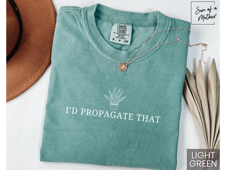 May include: Light green t-shirt with a white graphic of a potted plant and the text "I'd Propagate That".