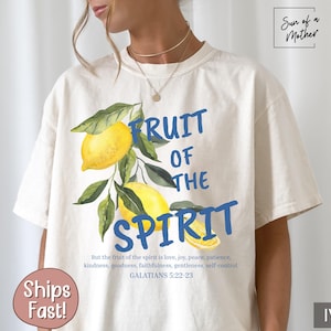 Op de afbeelding: Een wit T-shirt met een blauwe en gele citroenprint en de tekst "Fruit of the Spirit" in blauw. De tekst onder de afbeelding luidt "But the fruit of the spirit is love, joy, peace, patience, kindness, goodness, faithfulness, gentleness, self-control. Galatians 5:22-23".