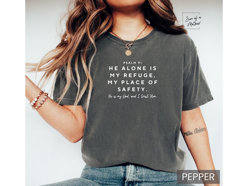 May include: A dark gray t-shirt with a white graphic that reads "PSALM 91 HE ALONE IS MY REFUGE, MY PLACE OF SAFETY. He is my God, and I trust Him".
