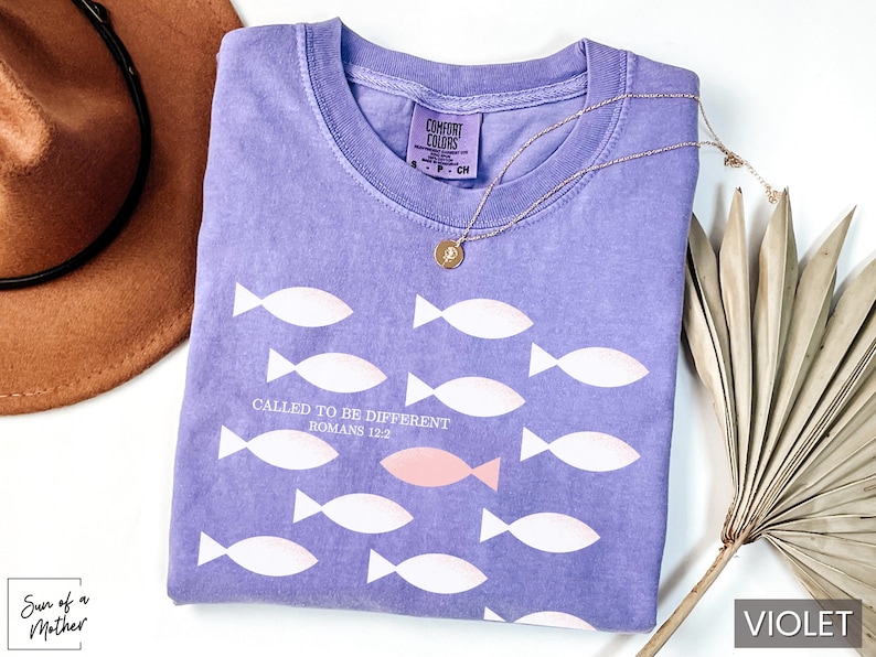 May include: A purple t-shirt with a white fish design and the text "Called to be different Romans 12:2".