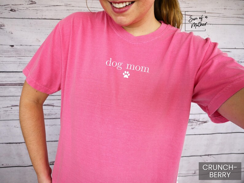 May include: A pink t-shirt with the text "dog mom" and a paw print in white.