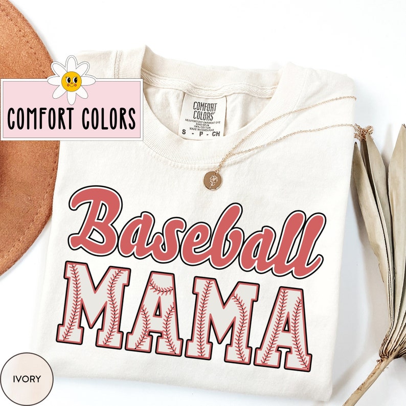 May include: A cream colored t-shirt with the words "Baseball Mama" in red and white. The letters are outlined in red and have a baseball stitch pattern inside.