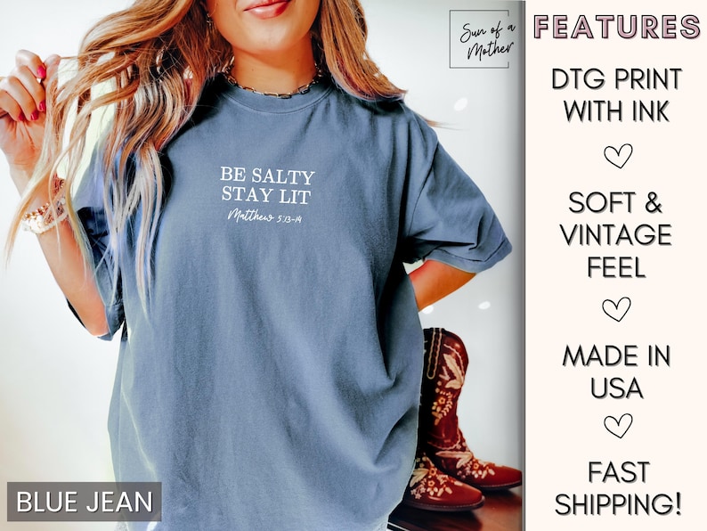 Puede incluir: Una camiseta azul vaquero con el texto "Be Salty Stay Lit Matthew 5:13-14" impreso en la parte delantera. La camiseta est&aacute; hecha con una sensaci&oacute;n suave y vintage y est&aacute; impresa con tinta.
