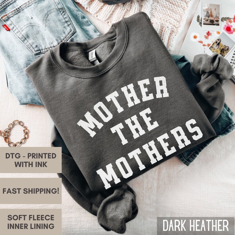 K&ouml;nnte beinhalten: Dunkelgrauer Sweatshirt mit dem Aufdruck "MOTHER THE MOTHERS" in Wei&szlig;.