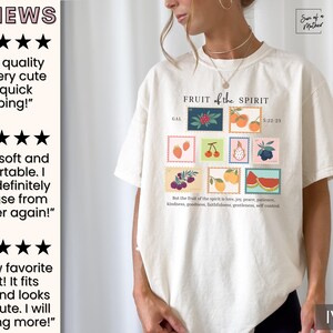 May include: Ivory t-shirt with a graphic of fruit and the text "FRUIT of the SPIRIT" and the scripture reference "GAL 5:22-23". The text below the graphic reads "But the fruit of the Spirit is love, joy, peace, patience, kindness, goodness, faithfulness, gentleness, self-control."