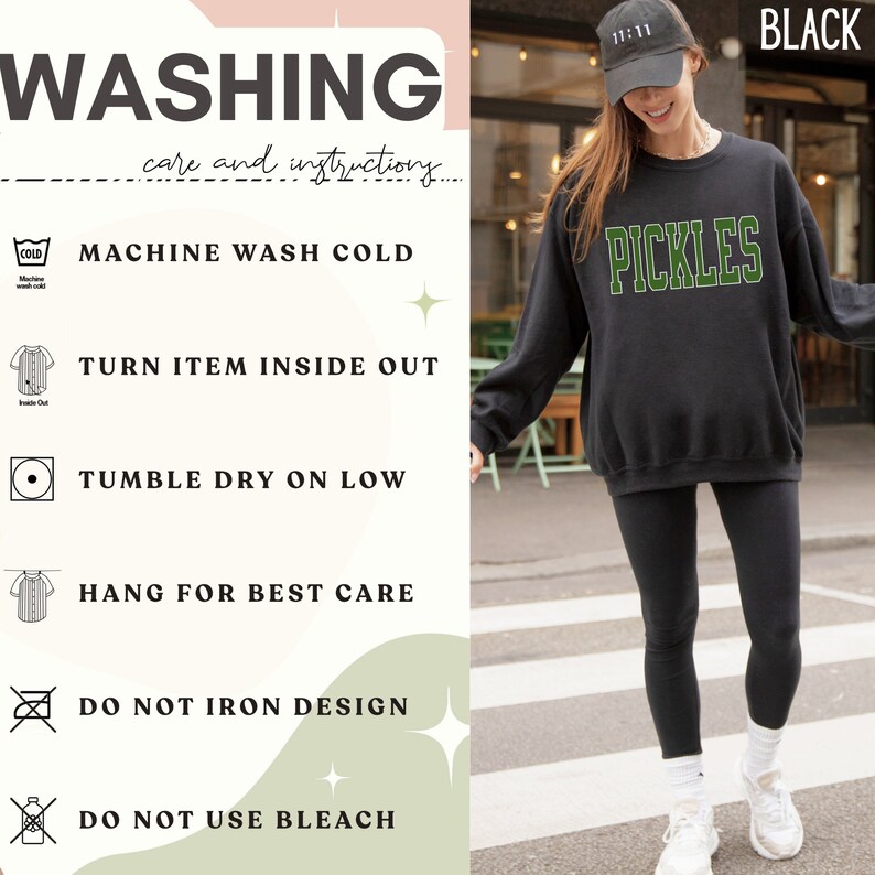 Op de afbeelding: Zwart sweatshirt met het woord "PICKLES" in groene letters. De wasinstructies staan ​​aan de linkerkant van de afbeelding. De instructies omvatten machinewas koud, item binnenstebuiten keren, drogen in de droger op lage temperatuur, hangen om te drogen, niet strijken op het ontwerp en geen bleekmiddel gebruiken.