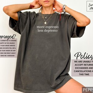 Op de afbeelding: Donkergrijze oversized t-shirt met de witte tekst "more espresso less depresso". Het shirt heeft een relaxte pasvorm en is gemaakt van een zacht materiaal. Het shirt is een casual kledingstuk.