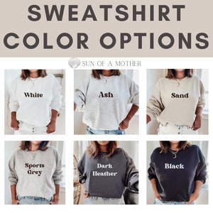 May include: Six different color options for a sweatshirt. The colors are white, ash, sand, sports grey, dark heather, and black. The text on each sweatshirt is the color name.