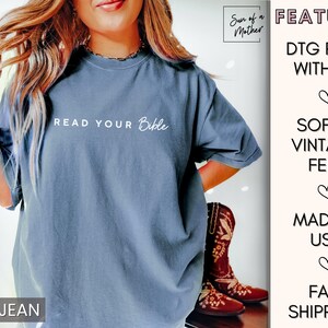 May include: A blue jean t-shirt with the text "READ YOUR Bible" printed in white. The shirt is soft and vintage-style.