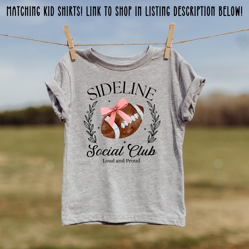 以下が含まれることがあります： 「SIDELINE Social Club Loud and Proud」というテキストとフットボールのグラフィックが描かれたグレーのTシャツです。