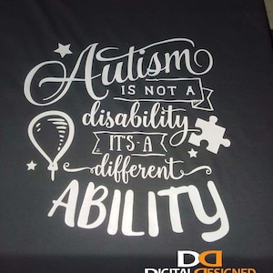 May include: A black t-shirt with white text that reads "Autism is not a disability it's a different ability". The text is in a stylized font and includes a star, a balloon, and a puzzle piece. The bottom of the shirt has a logo that reads "Digital Designed Custom Apparel & Graphics".