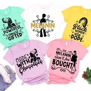 May include: Five different t-shirts with black text and graphics on various colored shirts. The shirts feature phrases like "Powerful, smart, gifted", "Melanin", "Black women are dope", "Made with chocolate", and "Melanin can't be bought".