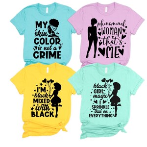 May include: Four t-shirts with different black and white graphic designs. The designs include the text "My skin color is not a crime", "Phenomenal woman that's me", "I'm black mixed with black", and "Black girl magic I sprinkle that on everything".