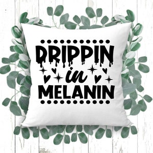 May include: White throw pillow with black text that reads "Drippin' in Melanin" with a dotted border and small hearts and stars.