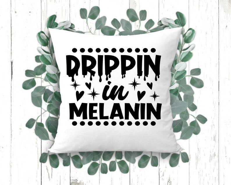 May include: White throw pillow with black text that reads "Drippin' in Melanin" with a dotted border and small hearts and stars.