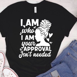 May include: Black t-shirt with a white graphic of a woman with an afro bun and the text "I AM who I AM your APPROVAL Isn't needed".