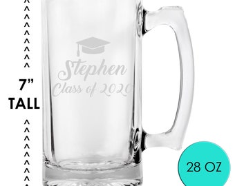 May include: A clear glass beer mug with a handle, engraved with "Stephen Class of 2020" and a graduation cap. The mug is 7 inches tall and holds 28 oz. Ideal for a graduation gift.