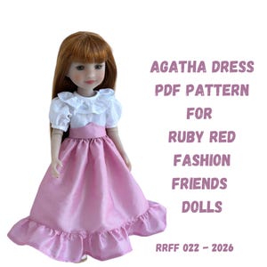 Könnte beinhalten: Eine Puppe in einem rosa Kleid mit weißem Rüschenoberteil. Das Kleid hat einen weiten Rock und einen Rüschensaum. Der Text rechts lautet "AGATHA DRESS PDF PATTERN FOR RUBY RED FASHION FRIENDS DOLLS" und "RRFF 022 - 2026".