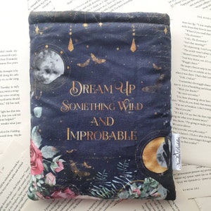 May include: A dark blue book cover with gold lettering that reads "Dream Up Something Wild and Improbable". The cover features a moon, stars, and floral designs in shades of pink, white, and gold.