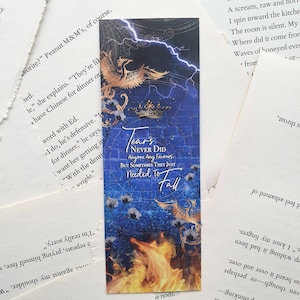 Op de afbeelding: Een blauwe en gouden bladwijzer met een phoenix-ontwerp en de tekst "Tears Never Did Anyone Any Favours But Sometimes They Just Needed To Fall".