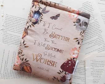 May include: A beige book sleeve with a floral design and a skull. The text on the sleeve reads "If I Cannot Be Better Than Then, I Will Become So Much Worse" with the hashtag "#ShakedCrafts".
