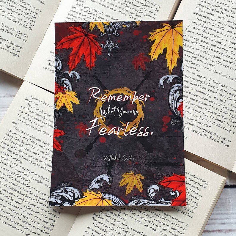May include: A motivational quote card with a dark grey background and a wreath of autumn leaves in shades of red, orange, and yellow. The quote reads "Remember What You Are Fearless."