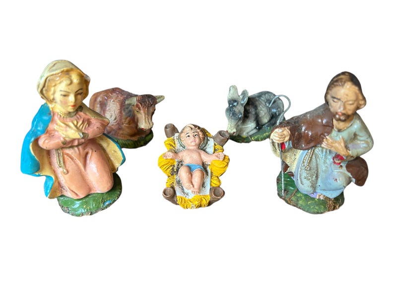 Pode incluir: Um pres&eacute;pio vintage com figuras de Maria, Jos&eacute;, o menino Jesus numa manjedoura, um burro e uma vaca. As figuras s&atilde;o pintadas com cores suaves e t&ecirc;m um aspeto cl&aacute;ssico e envelhecido.