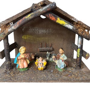 Pode incluir: Um pres&eacute;pio vintage com um est&aacute;bulo de madeira e figuras. O est&aacute;bulo tem um design r&uacute;stico com detalhes pintados. As figuras incluem Maria, Jos&eacute;, o menino Jesus e animais. A cena est&aacute; sobre uma base de madeira.