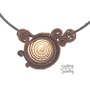 Op de afbeelding: Een bruine en zwarte koordketting met een spiraalvormig ontwerp. De hanger is een witte schelp met een spiraalvormig patroon. De ketting is gelabeld met "Knotting Jewelry".