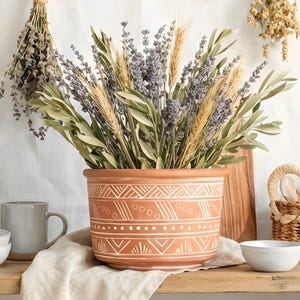 May include: A white ceramic mug with a black handle and the text "But First, Coffee" in a handwritten style. The mug is on a white surface. The mug is approximately 4 inches tall.