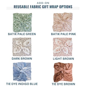 May include: Six square reusable fabric gift wraps tied in a knot at the center. The options include batik pale green, batik pale pink, dark brown, light brown, tie dye indigo blue, and tie dye brown. The text reads ADD-ON REUSABLE FABRIC GIFT WRAP OPTIONS.